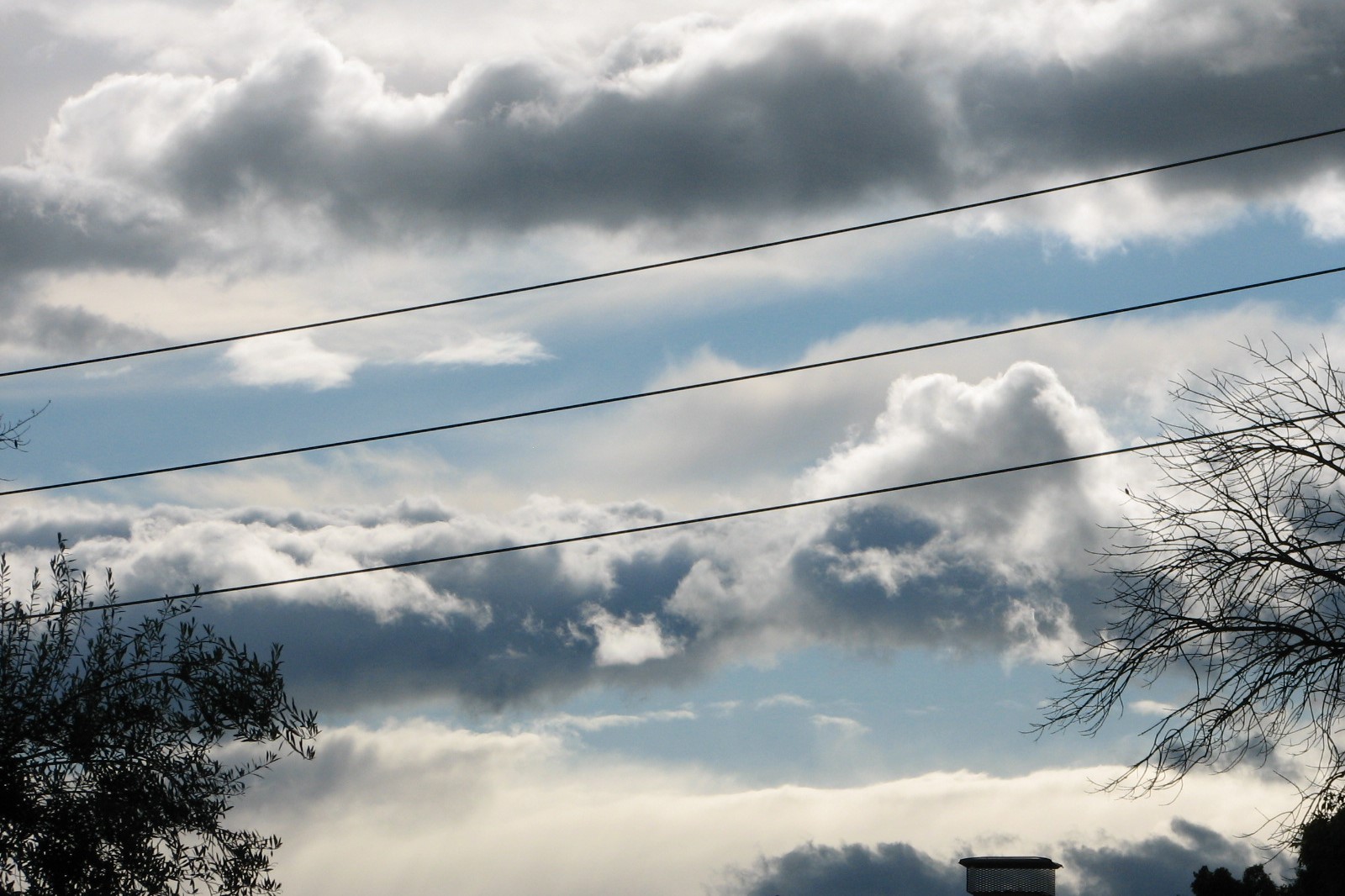 picture of blue, grey, and white clouds behind powerlines